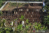Foto udara petugas yang sedang menggali liang lahat di lahan baru bagi pemakaman COVID-19 di TPU Kihafit, Leuwigajah, Cimahi, Jawa Barat, Minggu (8/8/2021). Pemerintah Kota Cimahi menjadikan TPU Kihafit sebagai lahan pemakaman baru bagi pasien yang meninggal dunia akibat COVID-19 dengan daya tampung 170 liang. ANTARA FOTO/Raisan Al Farisi/agr