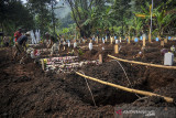 Petugas menggali liang lahat di lahan baru bagi pemakaman COVID-19 di TPU Kihafit, Leuwigajah, Cimahi, Jawa Barat, Minggu (8/8/2021). Pemerintah Kota Cimahi menjadikan TPU Kihafit sebagai lahan pemakaman baru bagi pasien yang meninggal dunia akibat COVID-19 dengan daya tampung 170 liang. ANTARA FOTO/Raisan Al Farisi/agr