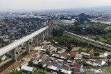 Kereta api melintas di dekat proyek konstruksi kereta api cepat Jakarta-Bandung di Lembah Teratai, Kabupaten Bandung Barat, Jawa Barat, Minggu (8/8/2021). Gubernur Jawa Barat Ridwan Kamil menyatakan uji coba kereta cepat Jakarta-Bandung ditargetkan akan dilaksanakan pada Oktober 2022 mendatang sementara pada Januari 2022, seluruh konstruksi beton proyek tersebut sudah tersambung sepenuhnya. ANTARA FOTO/Raisan Al Farisi/agr