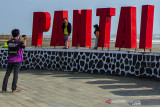 Pengunjung berfoto di landmark obyek wisata Pantai Sedari, Cibuaya, Karawang, Jawa Barat, Minggu (8/8/2021). Menteri Pariwisata dan Ekonomi Kreatif Sandiaga Uno memprediksi akan ada letupan wisata dari masyarakat usai pemberlakuan pembatasan kegiatan masyarakat (PPKM) untuk berwisata dan membeli produk ekonomi kreatif. ANTARA FOTO/M Ibnu Chazar/agr