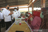 Menteri Kelautan dan Perikanan (KKP) Sakti Wahyu Trenggono (kiri) meninjau pelaksanaan vaksinasi bagi nelayan di tempat pelelangan ikan Misaya Mina, Eretan Wetan, Kandanghaur, Indramayu, Jawa Barat, Senin (9/8/2021). Selain melakukan peninjauan vaksinasi, Menteri KKP juga memberikan bantuan sembako bagi nelayan yang terdampak Pandemi COVID-19. ANTARA FOTO/Dedhez Anggara/agr