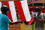 Pedagang bendera dan hiasan bernuansa merah putih musiman asal Bandung melayani pembeli pada masa Pemberlakukan Pembatasan Kegiatan Masyarakat (PPKM) COVID-19 di Kota Madiun, Jawa Timur, Minggu (8/8/2021). Pedagang tersebut mengaku omzet penjualan bendera dan hiasan yang dijual dengan harga antara Rp5 ribu hingga Rp400 ribu per buah tersebut turun bila dibanding tahun lalu dari rata-rata Rp350 ribu hingga Rp500 ribu menjadi Rp60 ribu hingga Rp190 ribu per hari. Antara Jatim/Siswowidodo