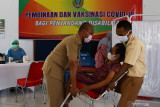Petugas menggotong penyandang disabilitas untuk disuntik vaksin COVID-19 saat pembinaan dan vaksinasi COVID-19 bagi penyandang disabilitas di Aula Shelter Dinas Sosial Pemberdayaan Perempuan dan Perlindungan Anak Kota Madiun, Jawa Timur, Senin (9/8/2021). Pemkot Madiun melakukan vaksinasi COVID-19 pada 89 orang penyandang disabilitas, lima Orang Dengan Gangguan Jiwa (ODGJ) dan enam orang pendamping disabilitas. Antara Jatim/Siswowidodo/zk