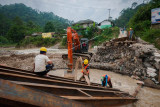 Pekerja membersihkan puing-puing jembatan yang terputus di Kampung Muhara, Lebak, Banten, Selasa (10/8/2021). Hujan lebat disertai angin kencang yang terjadi di daerah itu pada Senin (9/8/2021) malam, menyebabkan akses jembatan penghubung antarprovinsi Banten-Jawa Barat tersebut terputus akibat diterjang luapan air Sungai Ciberang. ANTARA FOTO/Muhammad Bagus Khoirunas/rwa.
