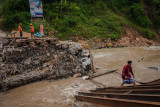 Warga terpaksa melintasi Sungai Ciberang akibat akses jembatan terputus di Kampung Muhara, Lebak, Banten, Selasa (10/8/2021). Hujan lebat disertai angin kencang yang terjadi di daerah itu pada Senin (9/8/2021) malam, menyebabkan akses jembatan penghubung antarprovinsi Banten-Jawa Barat tersebut terputus akibat diterjang luapan air Sungai Ciberang. ANTARA FOTO/Muhammad Bagus Khoirunas/rwa.