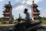  Warga melintas di depan pintu gerbang menuju kawasan wisata petilasan raja Kediri Sri Aji Jayabaya yang ditutup di Desa Menang, Kediri, Jawa Timur, Selasa (10/8/2021). Tradisi ritual satu suro penanggalan Jawa di petilasan raja Kediri yang terkenal dengan ramalan masa depan nusantara 'Jangka Jayabaya' tersebut ditiadakan guna menangkal penyebaran COVID-19. Antara Jatim/Prasetia Fauzani/zk