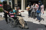 Polisi mendorong kursi roda penyandang disabilitas yang telah divaksin COVID-19 di Polda Jawa Timur, Surabaya, Jawa Timur, Selasa (10/8/2021). Polda Jawa Timur dan Polres jajaran menggelar vaksinasi COVID-19 bagi penyandang disabilitas dan Orang Dengan Gangguan Jiwa (ODGJ) dengan target 5 ribu penerima vaksin guna mewujudkan kekebalan kelompok. Antara Jatim/Didik Suhartono/zk