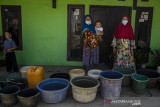 Warga mengumpulkan ember untuk diisi pasokan bantuan air bersih di Desa Kertajaya, Garut, Jawa Barat, Rabu (11/8/2021). Sedikitnya enam ribu jiwa dari 13 Rukun Warga di Desa Kertajaya tersebut mengalami kekurangan pasokan air bersih akibat kekeringan dan berkurangnya debit air pada sumber air warga saat musim kemarau yang terjadi tiap tahun. ANTARA FOTO/Novrian Arbi/agr
