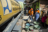 Warga mengisi ember dengan pasokan bantuan air bersih di Desa Kertajaya, Garut, Jawa Barat, Rabu (11/8/2021). Sedikitnya enam ribu jiwa dari 13 Rukun Warga di Desa Kertajaya tersebut mengalami kekurangan pasokan air bersih akibat kekeringan dan berkurangnya debit air pada sumber air warga saat musim kemarau yang terjadi tiap tahun. ANTARA FOTO/Novrian Arbi/agr
