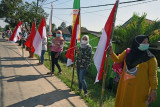 Sejumlah warga mengibarkan Bendera Merah Putih saat acara Gerakan Pengibaran 1000 Bendera Merah Putih di Kampung Curug, Kecamatan Petir, Serang, Banten, Kamis (12/8/2021). Acara yang digagas para Veteran Pejuang Kemerdekaan RI bersama tokoh pemuda itu digelar untuk menyambut peringatan HUT Kemerdekaan RI ke-76. ANTARA FOTO/Asep Fathulrahman/foc.