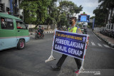 Petugas Kepolisian membawa papan informasi saat uji coba pemberlakuan ganjil genap di Jalan Asia-Afrika, Bandung, Jawa Barat, Jumat (13/8/2021). Dinas Perhubungan Kota Bandung bersama Satlantas Polrestabes Bandung melakukan uji coba ganjil genap di sejumlah ruas jalan protokol Kota Bandung guna menekan mobilitas masyarakat pada masa perpanjangan PPKM level 4. ANTARA FOTO/Raisan Al Farisi/agr