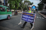 Petugas Kepolisian membawa papan informasi saat uji coba pemberlakuan ganjil genap di Jalan Asia-Afrika, Bandung, Jawa Barat, Jumat (13/8/2021). Dinas Perhubungan Kota Bandung bersama Satlantas Polrestabes Bandung melakukan uji coba ganjil genap di sejumlah ruas jalan protokol Kota Bandung guna menekan mobilitas masyarakat pada masa perpanjangan PPKM level 4. (ANTARA FOTO/Raisan Al Farisi/foc).