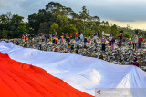 Sejumlah pegiat lingkungan yang tergabung dalam komunitas Republik Aer membentangkan bendera merah putih di Tempat Pembuangan Akhir Sampah (TPAS) Cianggir, Kota Tasikmalaya, Jawa Barat, Minggu (15/8/2021). Pembentangan bendera merah putih raksasa di TPAS tersebut dilakukan dalam rangkaian acara menyambut peringatan HUT Kemerdekaan ke-76 RI, sekaligus mengampanyekan kepedulian terhadap lingkungan dan menjaga ekosistem di masa pandemi COVID-19 serta memupuk rasa nasionalisme. ANTARA FOTO/Adeng Bustomi/agr