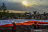 Sejumlah pegiat lingkungan yang tergabung dalam komunitas Republik Aer membentangkan bendera merah putih di Tempat Pembuangan Akhir Sampah (TPAS) Cianggir, Kota Tasikmalaya, Jawa Barat, Minggu (15/8/2021). Pembentangan bendera merah putih raksasa di TPAS tersebut dilakukan dalam rangkaian acara menyambut peringatan HUT Kemerdekaan ke-76 RI, sekaligus mengampanyekan kepedulian terhadap lingkungan dan menjaga ekosistem di masa pandemi COVID-19 serta memupuk rasa nasionalisme. ANTARA FOTO/Adeng Bustomi/agr