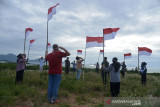 JURNALIS LINTAS MEDIA KIBARKAN MERAH PUTIHDI PERBUKITAN KAMPUNG. Sejumlah jurnalis dari berbagai media yang tergabung dalam Komunitas Pena Emas Aceh bersama TNI  mengibarkan bendera di Bukit Pengolahan Sampah kawasan pesisir pantai, Kampung Jawa, Banda Aceh, Senin (16/8/2021). Kegiatan pengibaran bendera di bukit pengolahan sampah yang masuk dalam kawasan situs sejarah Kerajaan Aceh dan kilometer nol kota Banda Aceh di tengah pandemi COVID-19 itu dalam rangka memeriahkan HUT ke-76 Kemerdekaan RI. ANTARA FOTO/Ampelsa.