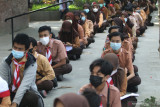 Sejumlah pelajar tingkat Sekolah Menengah Pertama (SMP) antre untuk mendapatkan suntikan vaksin COVID-19 di Taman Sekartaji, Kota Kediri, Jawa Timur, Senin (16/8/2021). Pemkot Kediri menggelar vaksinasi COVID-19 dosis pertama secara massal bagi pelajar SMP guna mewujudkan kekebalan kelompok sebagai persiapan pelaksanaan pembelajaran tatap muka.  Antara Jatim/Prasetia Fauzani/zk