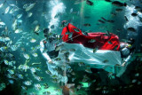 Penyelam mengibarkan bendera Merah Putih di dalam akuarium Koral Restaurant, The Apurva Kempinski Bali, Badung, Bali, Selasa (17/8/2021). Pengibaran bendera di bawah air oleh penyelam yang mengenakan seragam petugas upacara tersebut dilakukan untuk memeriahkan peringatan HUT ke-76 Kemerdekaan RI. ANTARA FOTO/Fikri Yusuf/nym.