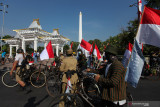 Sejumlah anggota Komunitas Sepeda Tua Indonesia Surabaya berjalan dengan membawa sepeda di Jalan Pahlawan, Surabaya, Jawa Timur, Selasa (17/8/2021). Bersepeda bersama menyusuri jalan-jalan di Surabaya dengan membawa bendera Merah Putih tersebut untuk memeriahkan HUT Ke-76 Kemerdekaan Republik Indonesia. Antara Jatim/Didik Suhartono/zk