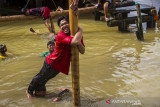 Peserta bahu membahu saat mengikuti lomba panjat pinang di bantaran Sungai Martapura, Banjarmasin, Kalimantan Selatan, Selasa (17/8/2021). Lomba panjat pinang swadaya masyarakat tersebut dalam rangka memeriahkan HUT ke-76 Kemerdekaan Republik Indonesia. Foto Antaranews Kalsel/Bayu Pratama S.