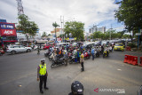 Petugas gabungan menghentikan sejenak pengguna jalan untuk berdiri tegak dan ambil sikap sempurna saat peringatan HUT Kemerdekaan ke-76 Republik Indonesia di Jalan Ahmad Yani, Banjarmasin, Kalimantan Selatan, Selasa (17/8/2021). Petugas gabungan dari Satpol PP, TNI dan POLRI bersama masyarakat melaksanakan kegiatan menghentikan kegiatan sejenak dan mengambil sikap sempurna selama tiga menit untuk menghormati Peringatan Detik-Detik Proklamasi HUT ke-76 Republik Indonesia saat lagu Indonesia Raya berkumandang. Foto Antaranews Kalsel/Bayu Pratama S.