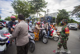 Petugas gabungan memberikan bendera dan menghentikan sejenak pengguna jalan untuk berdiri tegak dan ambil sikap sempurna saat peringatan HUT Kemerdekaan ke-76 Republik Indonesia di Jalan Ahmad Yani, Banjarmasin, Kalimantan Selatan, Selasa (17/8/2021). Petugas gabungan dari Satpol PP, TNI dan POLRI bersama masyarakat melaksanakan kegiatan menghentikan kegiatan sejenak dan mengambil sikap sempurna selama tiga menit untuk menghormati Peringatan Detik-Detik Proklamasi HUT ke-76 Republik Indonesia saat lagu Indonesia Raya berkumandang. Foto Antaranews Kalsel/Bayu Pratama S.