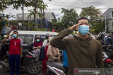 Sejumlah warga berhenti sejenak, berdiri tegak dan ambil sikap sempurna saat peringatan HUT Kemerdekaan ke-76 Republik Indonesia di Jalan Ahmad Yani, Banjarmasin, Kalimantan Selatan, Selasa (17/8/2021). Petugas gabungan dari Satpol PP, TNI dan POLRI bersama masyarakat melaksanakan kegiatan menghentikan kegiatan sejenak dan mengambil sikap sempurna selama tiga menit untuk menghormati Peringatan Detik-Detik Proklamasi HUT ke-76 Republik Indonesia saat lagu Indonesia Raya berkumandang. Foto Antaranews Kalsel/Bayu Pratama S.