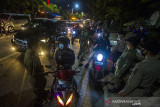 Petugas gabungan memeriksa dokumen syarat melakukan perjalanan pengendara yang hendak memasuki Kota Banjarmasin saat sosialisasi pemberlakuan pengetatan di Pos PPKM Jalan Ahmad Yani Km 6, Banjarmasin, Kalimantan Selatan, Rabu (18/8/2021)malam. Polresta Banjarmasin dalam pelaksanaan Pemberlakuan Pembatasan Kegiatan Masyarakat (PPKM) Level 4 mendirikan enam posko pengetatan untuk melakukan pemeriksaan terhadap masyarakat yang masuk ke Kota setempat sesuai instruksi Mendagri No. 34 Tahun 2021. Foto Antaranews Kalsel/Bayu Pratama S.