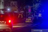 Petugas kepolisian mengarahkan pengguna jalan saat pengalihan arus penerapan jam malam di Jalan Ahmad Yani Km 2, Banjarmasin, Kalimantan Selatan, Kamis (19/8/2021). Polresta Banjarmasin mulai memberlakukan penerapan jam malam saat PPKM Level 4 mulai pukul 20.00 WITA dengan menutup akses ke dalam kota dan mematikan lampu penerangan jalan umum utama di Kota Banjarmasin guna mengurangi serta membatasi mobilitas warga untuk menekan dan memutus mata rantai penyebaran virus COVID-19. Foto Antaranews Kalsel/Bayu Pratama S.