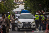 Petugas gabungan memeriksa dokumen syarat melakukan perjalanan pengemudi yang hendak memasuki Kota Banjarmasin saat pemberlakuan pengetatan di Jalan Ahmad Yani, Banjarmasin, Kalimantan Selatan, Kamis (19/8/2021). Pemerintah Kota Banjarmasin bersama Kodim 1007/Banjarmasin dan Polresta Banjarmasin dalam pelaksanaan PPKM Level 4 melakukan pengetatan kepada masyarakat yang hendak memasuki Kota Banjarmasin guna menekan penyeberan dan penularan COVID-19. Foto Antaranews Kalsel/Bayu Pratama S.