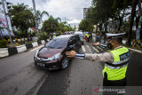 Petugas kepolisian mengarahkan untuk putar balik kepada pengemudi karena tidak memenuhi dokumen syarat melakukan perjalanan yang hendak memasuki Kota Banjarmasin saat pemberlakuan pengetatan di Jalan Ahmad Yani, Banjarmasin, Kalimantan Selatan, Kamis (19/8/2021). Pemerintah Kota Banjarmasin bersama Kodim 1007/Banjarmasin dan Polresta Banjarmasin dalam pelaksanaan PPKM Level 4 melakukan pengetatan kepada masyarakat yang hendak memasuki Kota Banjarmasin guna menekan penyeberan dan penularan COVID-19. Foto Antaranews Kalsel/Bayu Pratama S.