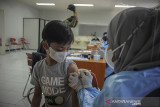 Tenaga kesehatan menyuntikkan vaksin COVID-19 kepada seorang anak saat vaksinasi massal di Sasana Budaya Ganesha (Sabuga), Bandung, Jawa Barat, Jumat (20/8/2021). Presiden Joko Widodo menargetkan jumlah penerima vaksin COVID-19 hingga akhir Agustus 2021 di Indonesia mencapai 100 juta guna membentuk kekebalan kelompok sehingga pandemi COVID-19 segera berakhir. ANTARA FOTO/Raisan Al Farisi/agr