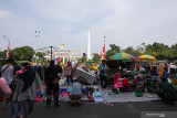 Warga mengunjungi pasar dadakan di ruas Jalan Pahlawan, Surabaya, Jawa Timur, Minggu (22/8/2021). Para pedagang berjualan kembali di hari Minggu pagi di pasar dadakan di kawasan Tugu Pahlawan tersebut yang sebelumnya sempat tidak diperbolehkan menggelar  dagangannya karena pandemi COVID-19. Antara Jatim/Didik Suhartono/zk