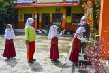 Siswa kelas III antre mencuci tangannya sebelum mengikuti Pembelajaran Tatap Muka (PTM) terbatas di SDN Dadaha, Kota Tasikmalaya, Jawa Barat, Senin (23/8/2021). Pemerintah Kota Tasikmalaya mengizinkan sekolah belajar tatap muka tingkat PAUD, SD, SMP dan SMA dengan melaksanakan protokol kesehatan COVID-19 yang ketat serta membatasi kapasitas jumlah siswa sebanyak 50 persen. ANTARA FOTO/Adeng Bustomi/agr
