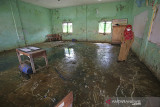 Seorang guru melihat bekas banjir rob yang masuk ke dalam ruang kelas SDN Eretan Wetan 2, Kandanghaur, Indramayu, Jawa Barat, Senin (23/8/2021). Banjir rob yang sering melanda daerah itu membuat aktivitas belajar di sekolah tersebut terganggu. ANTARA FOTO/Dedhez Anggara/agr