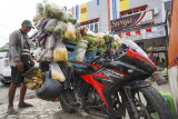 Pedagang sayur keliling Budi (63) berjualan di depan emperan toko, Entrop, Kota Jayapura, Papua, Minggu (22/8/2021). Budi sehari-hari beraktivitas sebagai pedagang sayur keliling gunakan motor sport Honda CBR 6 speed dengan harga puluhan juta rupiah. ANTARA FOTO/Indrayadi TH/foc.