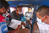 Petugas medis memeriksa kesehatan warga sebelum menerima vaksin COVID-19 secara drive thru di Karawang, Jawa Barat, Selasa (24/8/2021). Polres Karawang memberikan vaksinasi COVID-19 secara drive thru dengan target 150 dosis vaksin per hari sebagai Bhakti Kesehatan Bhayangkara untuk negeri guna menekan lonjakan kasus COVID-19 di Indonesia. ANTARA FOTO/M Ibnu Chazar/agr
