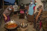 Sejumlah warga menyiapkan makanan untuk warga yang melakukan isolasi mandiri di dapur umum Desa Langaleso, Sigi, Sulawesi Tengah, Senin (23/8/2021). Warga desa setempat menginisiasi dapur umum secara swadaya untuk membantu memenuhi kebutuhan makan dan minum warga lainnya yang menjalani isolasi mandiri akibat terpapar COVID-19. ANTARA FOTO/Basri Marzuki/aww.