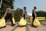 Polisi membawa paket bantuan sembako untuk dibagikan ke warga di Surabaya, Jawa Timur, Rabu (25/8/2021). Pembagian paket bantuan kepada warga yang dilakukan Alumni Akpol 1993 Pesat Gatra tersebut untuk meringankan beban ekonomi warga yang terdampak pandemi COVID-19. Antara Jatim/Didik Suhartono/zk