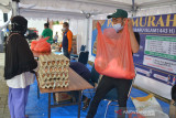 PASAR MURAH SEMBAKO  DI TENGAH PANDEMI COVID-19. Warga berbelanja kebutuhan pokok dengan menerapkan protokol kesehatan saat berlangsung pasar murah di Banda Aceh, Aceh, Rabu (25/8/2021). Pasar murah yang digelar pemerintah setempat dalam rangkaian peringatan Tahun Baru Hijriyah dan berlangsung hingga tanggal 1 September 2021  itu menyediakan paket sembako terdiri dari beras, gula, minyak goreng, tepung terigu dan telur ayam dengan mendapat harga subsidi hingga 30 persen untuk  membantu perekonomian warga yang terdampak pandemi COVID-19. ANTARA FOTO/Ampelsa.