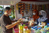 Anggota Keluarga Penerima Manfaat (KPM) melayani pembeli di warung Program Keluarga Harapan (PKH) Shop, Kabupaten Ciamis, Jawa Barat, Selasa (24/8/2021). Program Keluarga Harapan Ciamis mendirikan 12 PKH Shop untuk memfasilitasi pemberdayaan keluarga penerima manfaat yang masih aktif untuk menunjang sarana tempat kegiatan usaha sekaligus belajar berwirausaha dengan menjual berbagai produk makanan hasil olah KPM serta menyediakan sarana pojok baca. ANTARA FOTO/Adeng Bustomi/agr