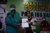 Ketua Tim Penggerak PKK Kota Madiun Yuni Maidi (kiri) bersama ibu hamil memperlihatkan Kartu Vaksinasi COVID-19 di RSUD Kota Madiun, Jawa Timur, Kamis (26/8/2021). Pemkot Madiun menggelar Vaksinasi COVID-19 pada ibu hamil dengan sasaran 374 orang selama dua hari. Antara Jatim/Siswowidodo/zk