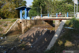 Pengendara melintas di dekat Dam Sarangan di Wonoasri, Kabupaten Madiun, Jawa Timur, Rabu (25/8/2021). Dam yang merupakan sarana irigasi teknis untuk lahan pertanian seluas 1.273 hektare tersebut sudah tidak berfungsi sejak sekitar seminggu terakhir karena sungai tersebut telah mengering akibat musim kemarau. Antara Jatim/Siswowidodo/zk