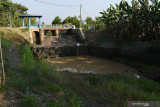 Pengendara melintas di dekat Dam Sarangan di Wonoasri, Kabupaten Madiun, Jawa Timur, Rabu (25/8/2021). Dam yang merupakan sarana irigasi teknis untuk lahan pertanian seluas 1.273 hektare tersebut sudah tidak berfungsi sejak sekitar seminggu terakhir karena sungai tersebut telah mengering akibat musim kemarau. Antara Jatim/Siswowidodo/zk