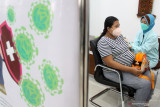  Petugas kesehatan menyuntikan vaksin COVID-19 kepada ibu hamil di gedung Hemodialisis Rumah Sakit Umum Daerah (RSUD) Sidoarjo, Jawa Timur, Kamis (26/8/2021). Sebanyak 200 dosis vaksin diberikan kepada ibu hamil dengan usia kehamilan 13 minggu hingga 33 minggu tersebut sebagai booster agar antibodi di dalam tubuh membentuk sistem imun yang kuat. Antara Jatim/Umarul Faruq/zk