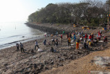 Warga memungut sampah di pinggir pantai di kawasan Kedung Cowek, Surabaya, Jawa Timur, Minggu (29/8/2021). Kegiatan bersih-bersih sampah yang dilakukan oleh Tunas Hijau dan warga tersebut sebagai wujud kepedulian terhadap kebersihan lingkungan di kawasan pantai. Antara Jatim/Didik Suhartono/zk