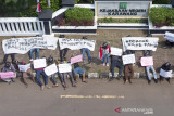 Foto udara sejumlah pengunjuk rasa membawa poster saat aksi damai usut tuntas pemotongan dana Bantuan Sosial Tunai (BST) di depan kantor Kejaksaaan Negeri, Karawang, Jawa Barat, Senin (30/8/2021). Aksi tersebut menuntut KPK dan Kemensos menangani kasus pemotongan dana Bantuan Sosial Tunai (BST) 281 warga Karawang yang tadinya Rp600 ribu menjadi Rp300 ribu. ANTARA FOTO/M Ibnu Chazar/agr