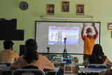 Seorang Guru (kanan) menerangkan materi pembelajaran kepada murid SMPN 2 Bekasi secara hybrid atau kombinasi antara tatap muka terbatas dengan pembelajaran secara daring di Bekasi, Jawa Barat, Rabu (1/9/2021). Sebanyak 66 SMP menggelar Pembelajaran Tatap Muka (PTM) dengan jumlah 50 persen murid dan menerapkan protokol kesehatan. ANTARA FOTO/ Fakhri Hermansyah/hp.