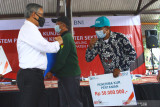 Ketua Dewan Komisioner Otoritas Jasa Keuangan (OJK) Wimboh Santoso (kiri) memberi salam pada petani penerima KUR didampingi Bupati Malang Sanusi (kiri) saat Kunjungan Ekosistem Pembiayaan KUR Klaster Sektor Pertanian di Kebun Pembibitan Alpukat Pameling, Lawang, Malang, Jawa Timur, Sabtu (4/9/2021). Otoritas Jasa Keuangan berupaya meningkatkan akses pembiayaan perbankan kepada petani dengan  memperbanyak pembentukan klaster pertanian dan menciptakan ekosistem guna mempermudah para petani dalam pengajuan, pencairan, penjaminan kredit serta memasarkan produk pertanian. Antara Jatim/Ari Bowo Sucipto/zk