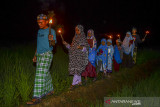 Sejumlah anak berjalan di pematang sawah sambil membawa obor usai mengikuti Program Magrib Mengaji di Masjid Baetul Mutaqin, Kampung Munggangwareng, Kabupaten Ciamis, Jawa Barat, Rabu (8/9/2021). Pemerintah Provinsi Jawa Barat bekerjasama dengan para kiai dan Majelis Ulama Indonesia (MUI) di Jabar meluncurkan Program Maghrib Mengaji dan Membaca Al- Quran di masjid untuk menjaga tradisi dan budaya umat Islam di nusantara. ANTARA FOTO/Adeng Bustomi/agr
