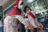 Seorang ibu mencoba ukuran seragam sekolah motif batik untuk anaknya saat belanja kebutuhan sekolah di Tulungagung, Jawa Timur, Rabu (8/9/2021). Penjualan seragam sekolah di toko-toko seragam setempat meningkat pesat seiring akan dimulainya pembelajaran tatap muka terbatas (PTMT) tingkat SD, SMP dan SMA di daerah itu pasca perubahan status dari zona merah (PPKM level 4) ke zona oranye (PPKM level 3). Antara Jatim/Destyan Sujarwoko/zk